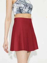 Crimson A-line mini skirt with a smooth finish, styled with a cropped top.