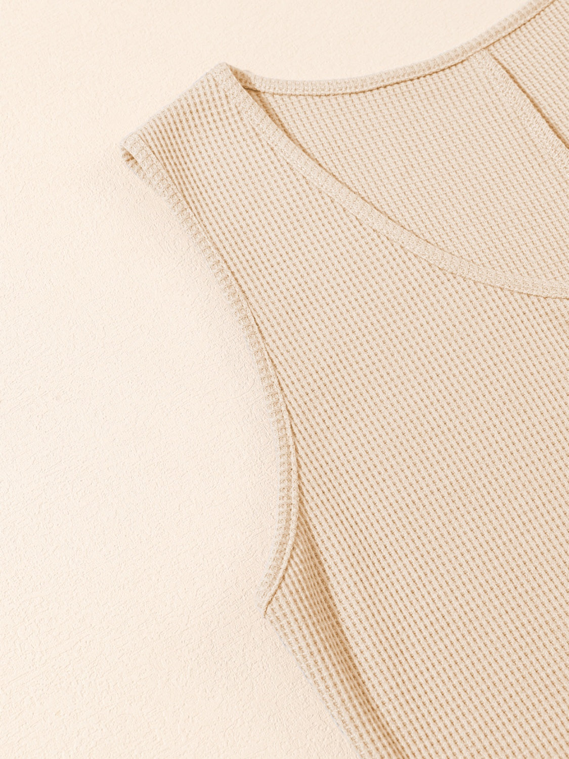 Camel waffle knit button-down romper detail with V-neck and cap sleeves.