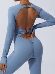 Light blue long sleeve sculpting jumpsuit with open back and ruched detail.