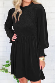 Black velvet mini dress with smocked bodice and long puff sleeves.