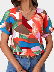 Geometric print V-neck blouse with rolled short sleeves in multicolor.