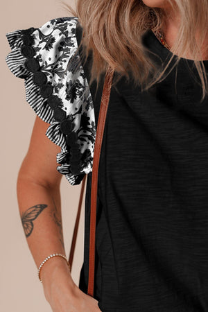 Black tee with embroidered floral flutter sleeves and striped trim.