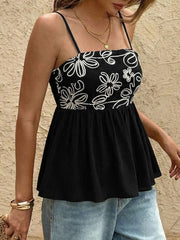 Black peplum cami top with white floral embroidery and smocked bodice.