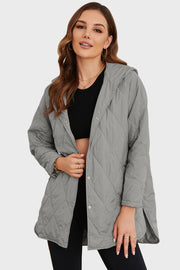Light gray quilted hooded parka with snap front closure and side slits.