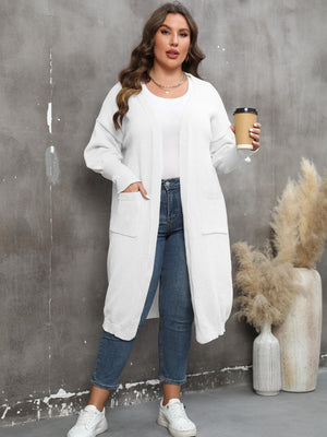 White oversized knit duster cardigan with patch pockets and ribbed cuffs.
