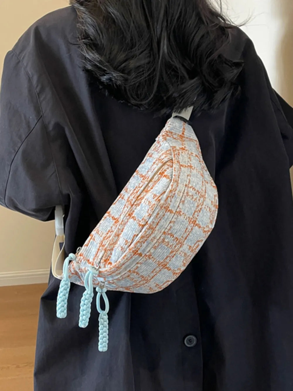 Textured tweed belt bag in pink plaid with braided light blue pulls.