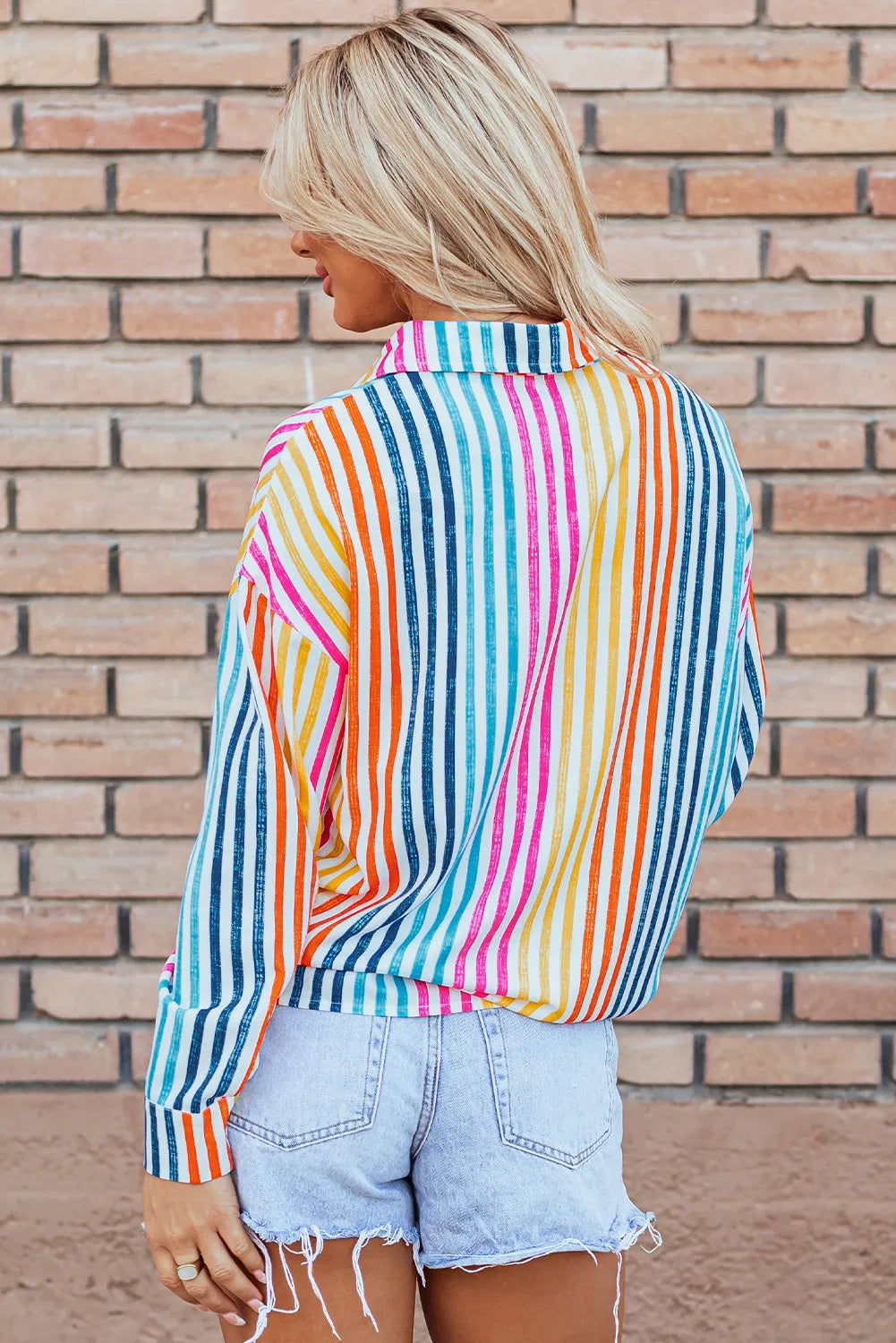 Rainbow stripe relaxed fit button-down shirt with a collared neckline and long sleeves.