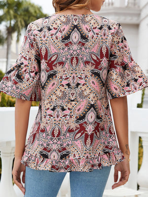 Paisley print blouse with ruffle hem and flutter sleeves in burgundy and pink tones.