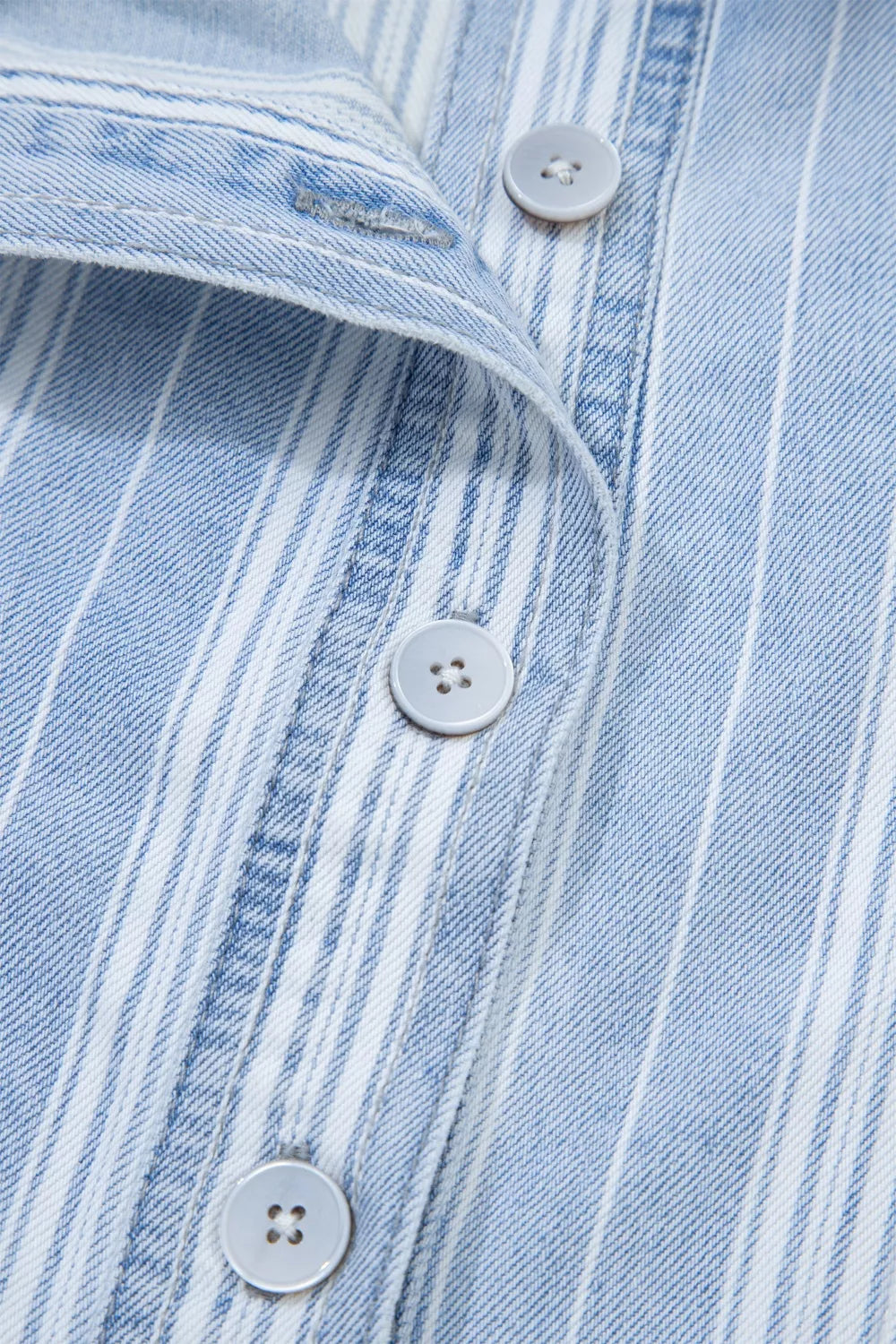 Denim shacket with blue and white vertical stripes, button-down front, and light grey buttons.