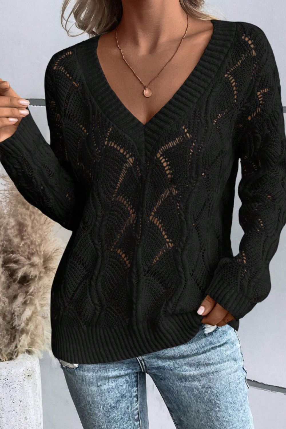 Black openwork knit v-neck pullover sweater with cable detail and ribbed trim.