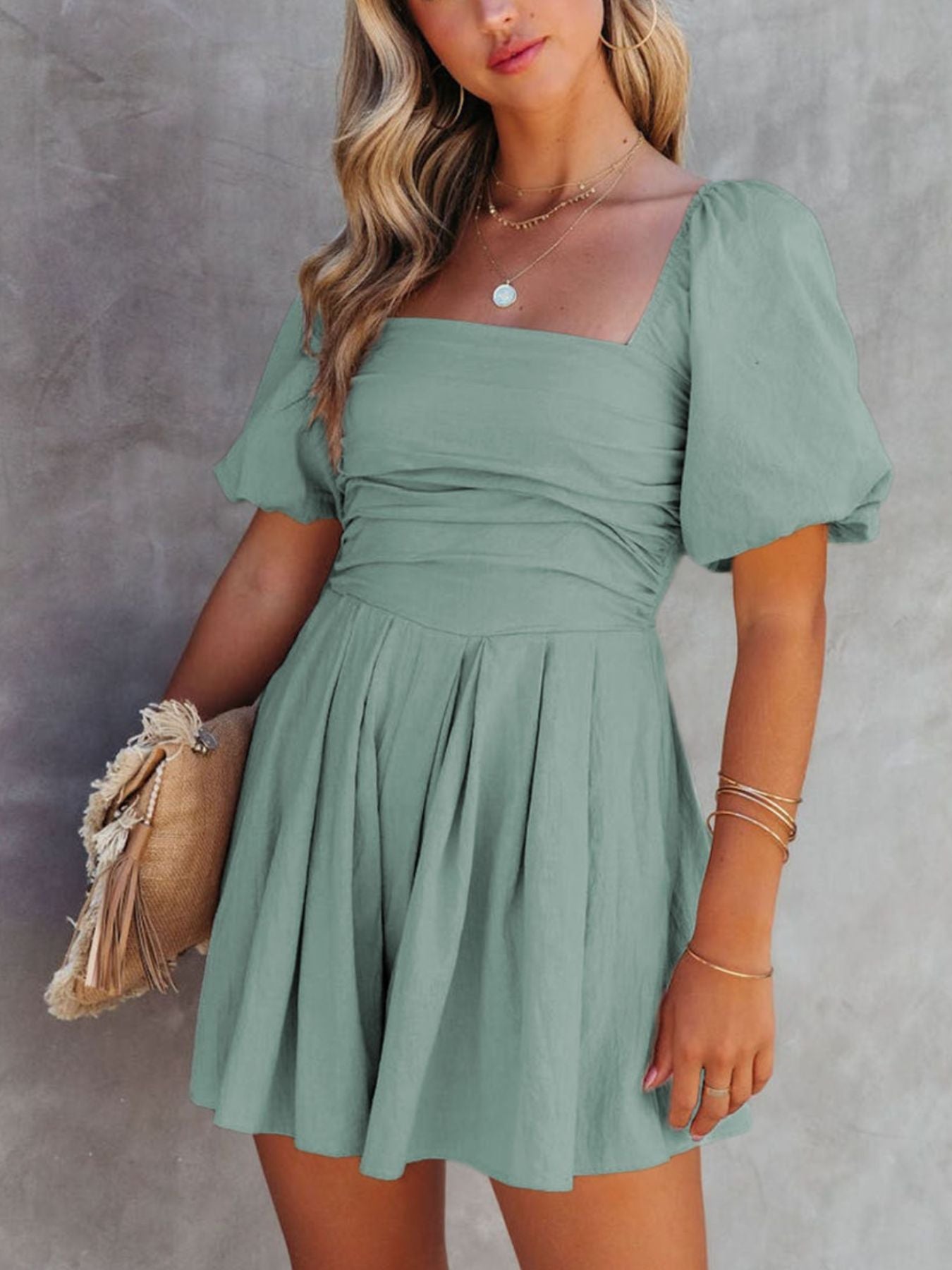 Sage ruched puff sleeve square neck cotton romper with pleated shorts.