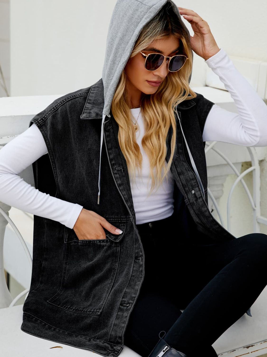 Sleeveless dark denim utility vest with gray hood and chest pockets