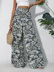 Tropical leaf print palazzo trousers in navy with green and white foliage.