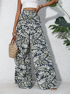 Tropical leaf print palazzo trousers in navy with green and white foliage.