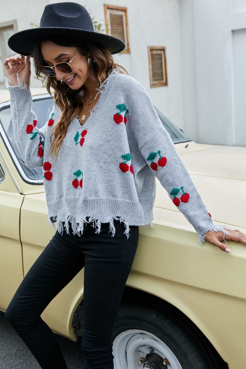 Gray V-neck sweater with cherry motif and frayed hem