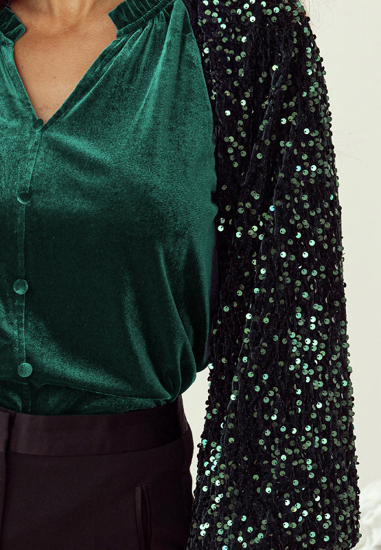 Dark green velvet blouse with sequin sleeves and ruffled collar.