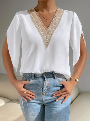 White polyester blouse with lace-trimmed V-neck and cape sleeves.