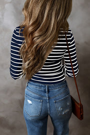 Ribbed stripe long sleeve henley top in dark navy and white, paired with distressed denim jeans.