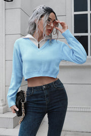 Light blue cropped acrylic sweater with zip detail and white collar, V-neck, long sleeves.