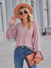 Blush pink eyelet blouse with lace trim V-neck and smocked cuffs.