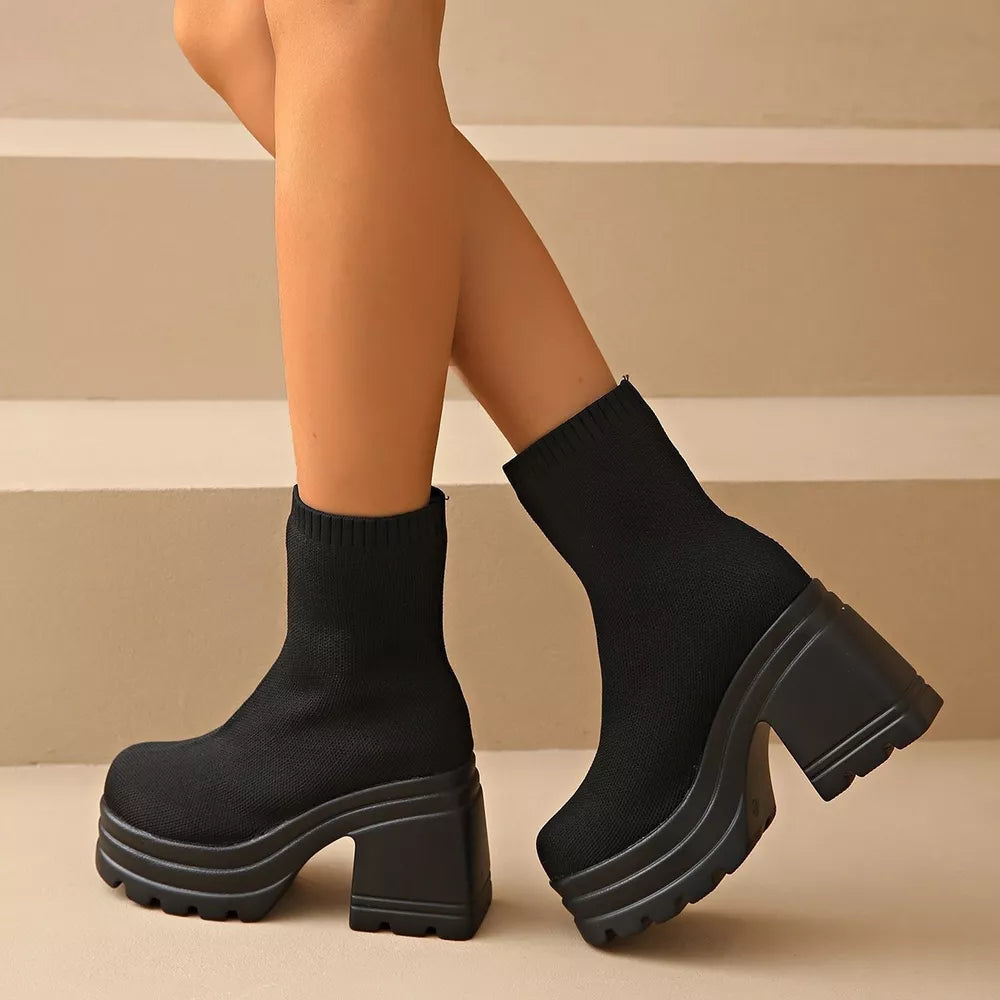 Black sock ankle boots with round toe and chunky platform heel.