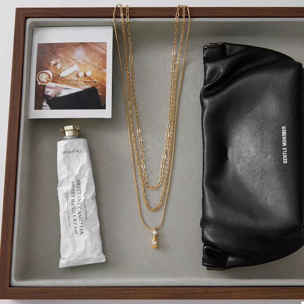 Gold three layered pendant necklace with delicate chains and small diamond accents.