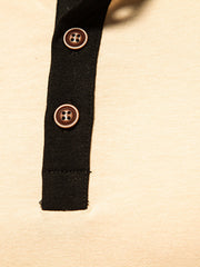 Men's long sleeve henley t-shirt in beige with black placket and brown buttons.