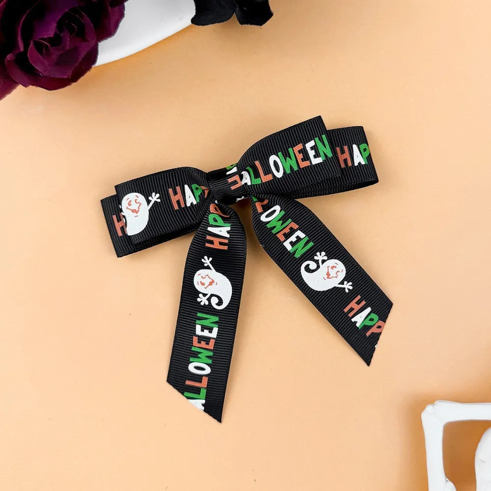 Black Halloween print bow hair clip with ghost and text detail