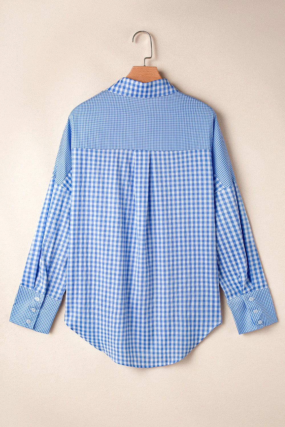Light blue gingham oversized shirt with button cuffs and a patch pocket detail.