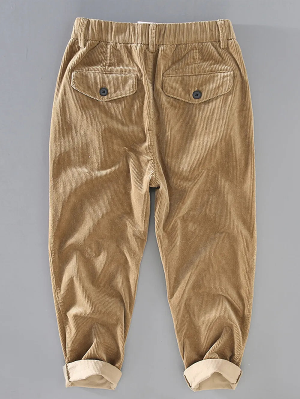 Khaki corduroy pants with elastic waist and button flap back pockets.