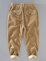 Khaki corduroy pants with elastic waist and button flap back pockets.