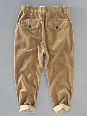 Khaki corduroy pants with elastic waist and button flap back pockets.