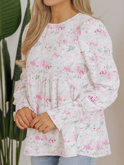 Blouse with smocked waist and cuffs, featuring a pink and green floral print on white.