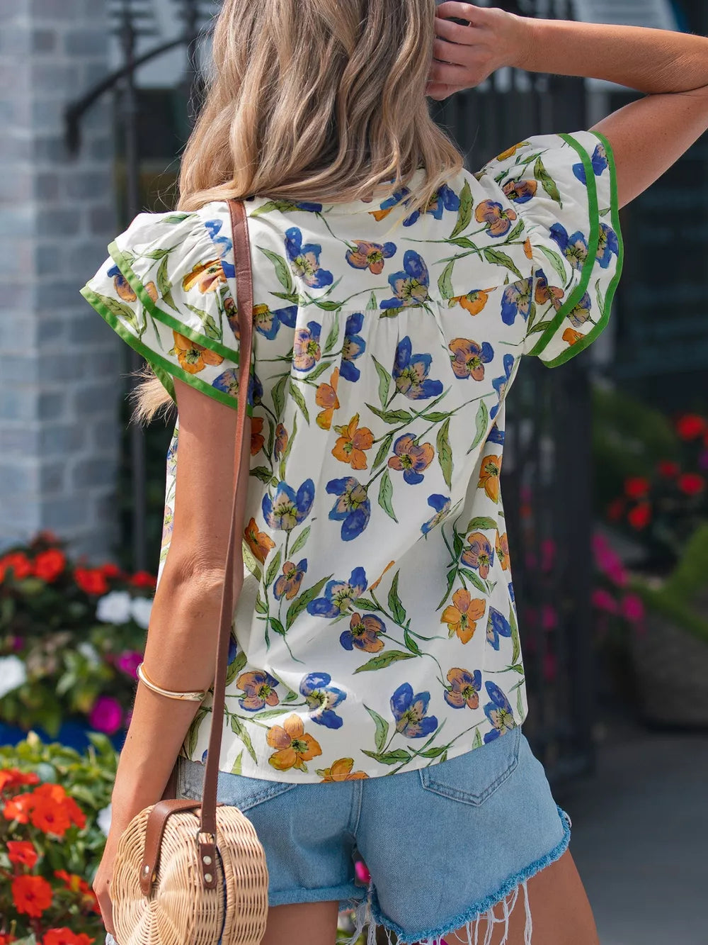 Cotton floral print shirt with ruffled sleeves and green trim.