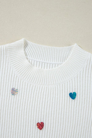 White ribbed knit sweater with scattered heart embellishments.