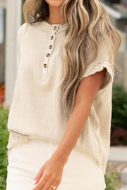 Beige textured gauze henley blouse with raw edges and button placket.