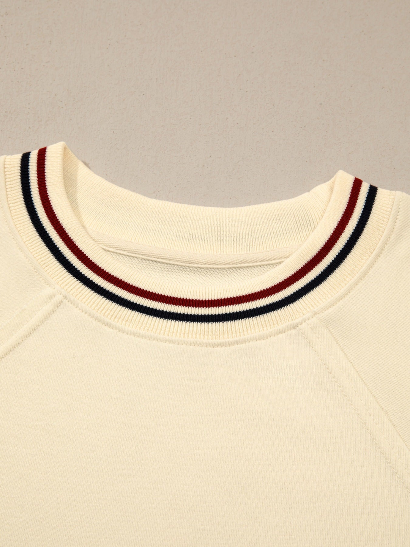 Beige cotton tunic top with a striped neckline detail and raglan sleeves.