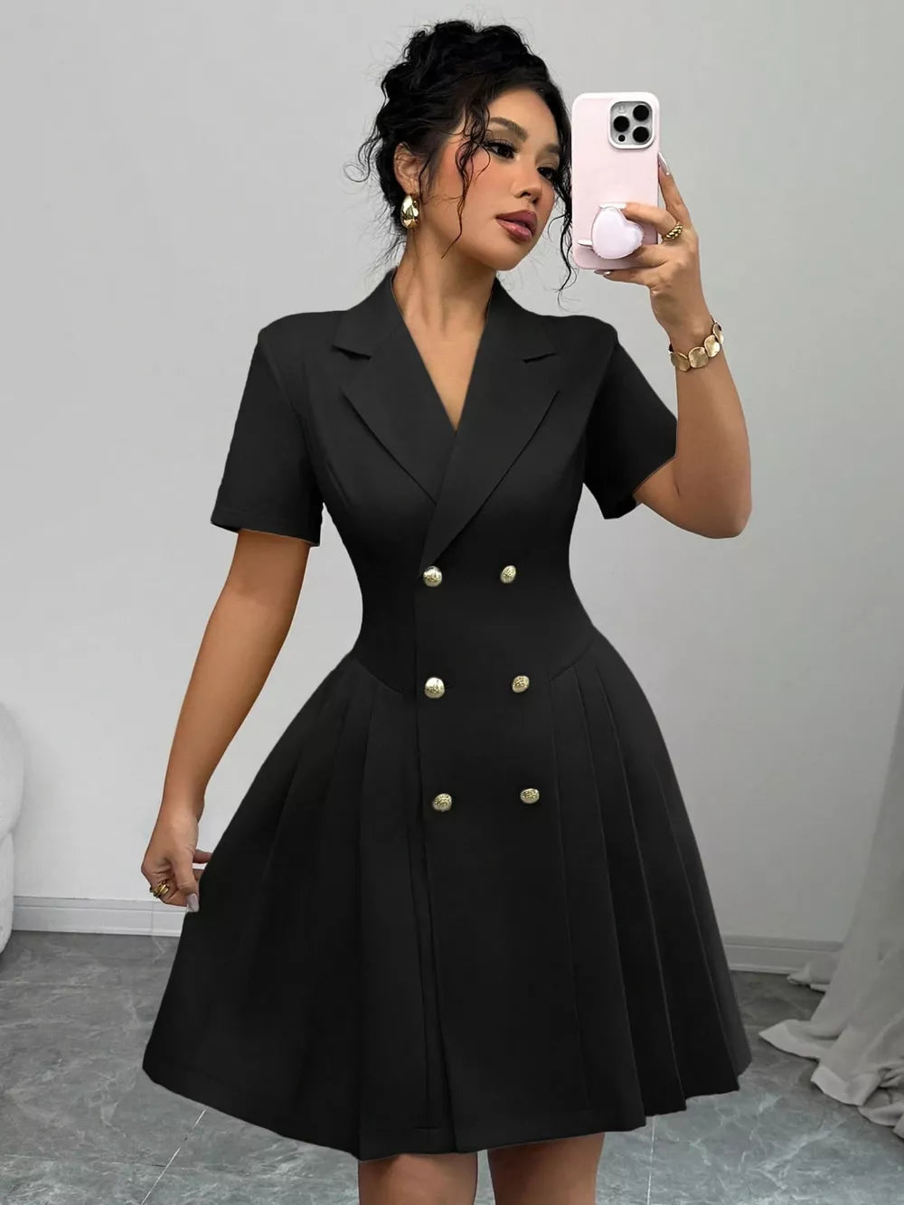 Black double-breasted pleated blazer dress with gold buttons and short sleeves.