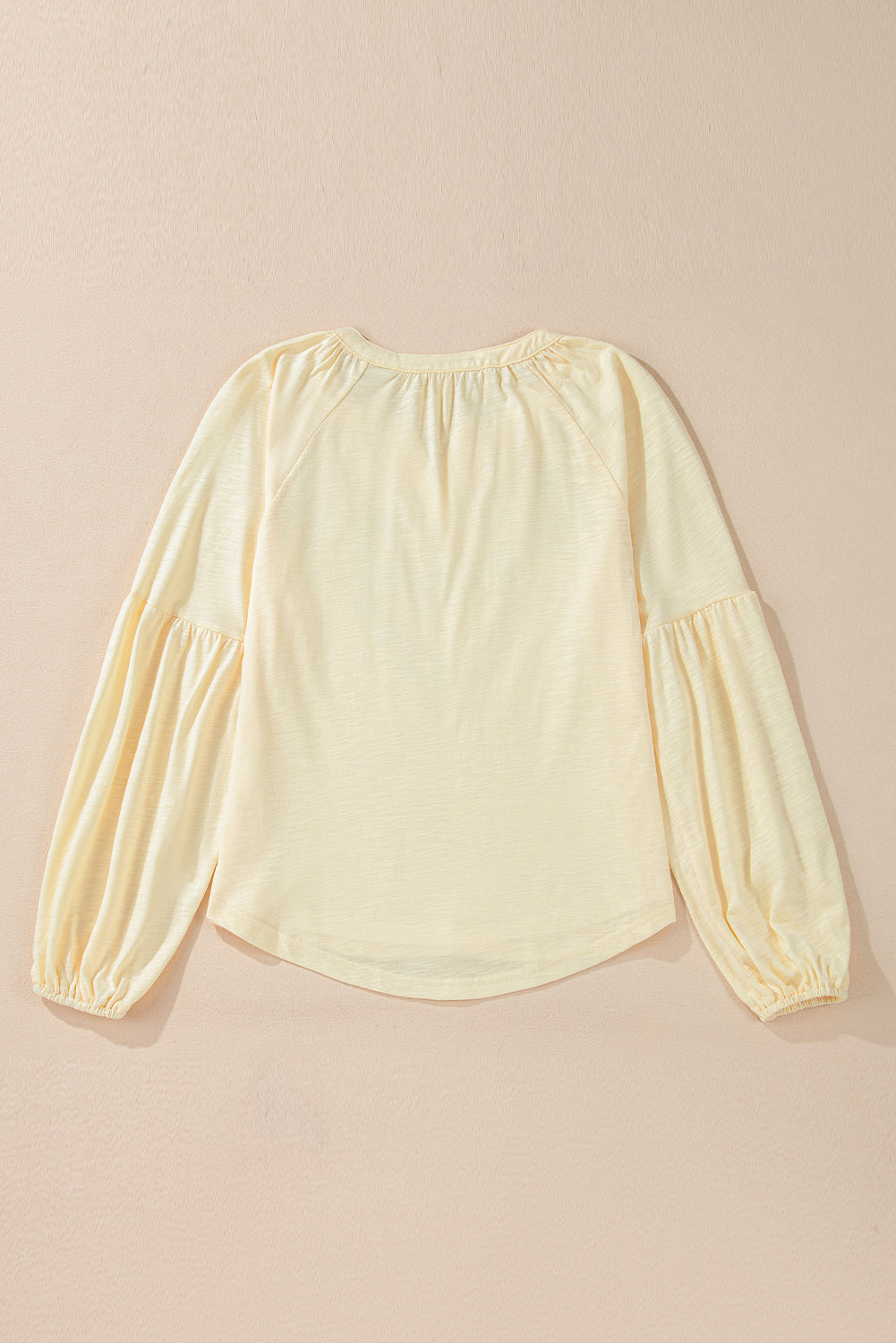 Pastel yellow blouse with gathered neckline and voluminous poet sleeves.