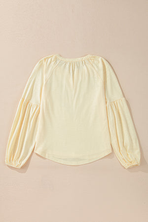 Pastel yellow blouse with gathered neckline and voluminous poet sleeves.
