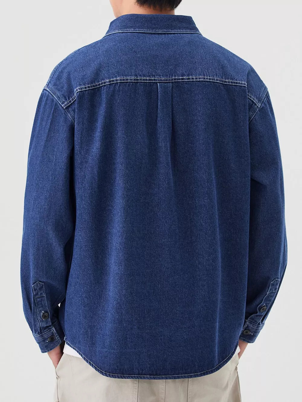 Men's dark blue denim overshirt with button cuffs and back yoke detail.