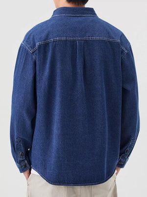 Men's dark blue denim overshirt with button cuffs and back yoke detail.