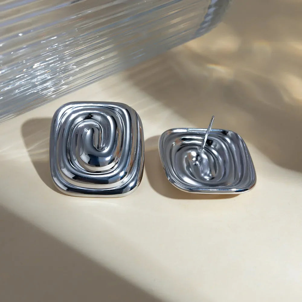 Silver sculpted swirl square earrings with a contemporary design.