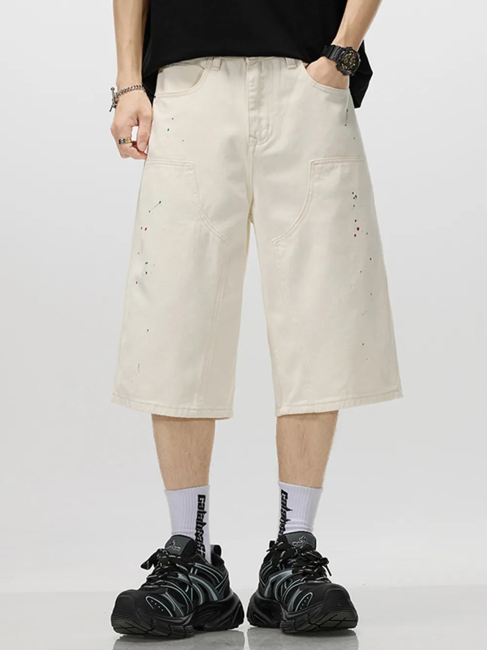 Cream cotton denim capris for him with artistic paint splatters and a relaxed fit.