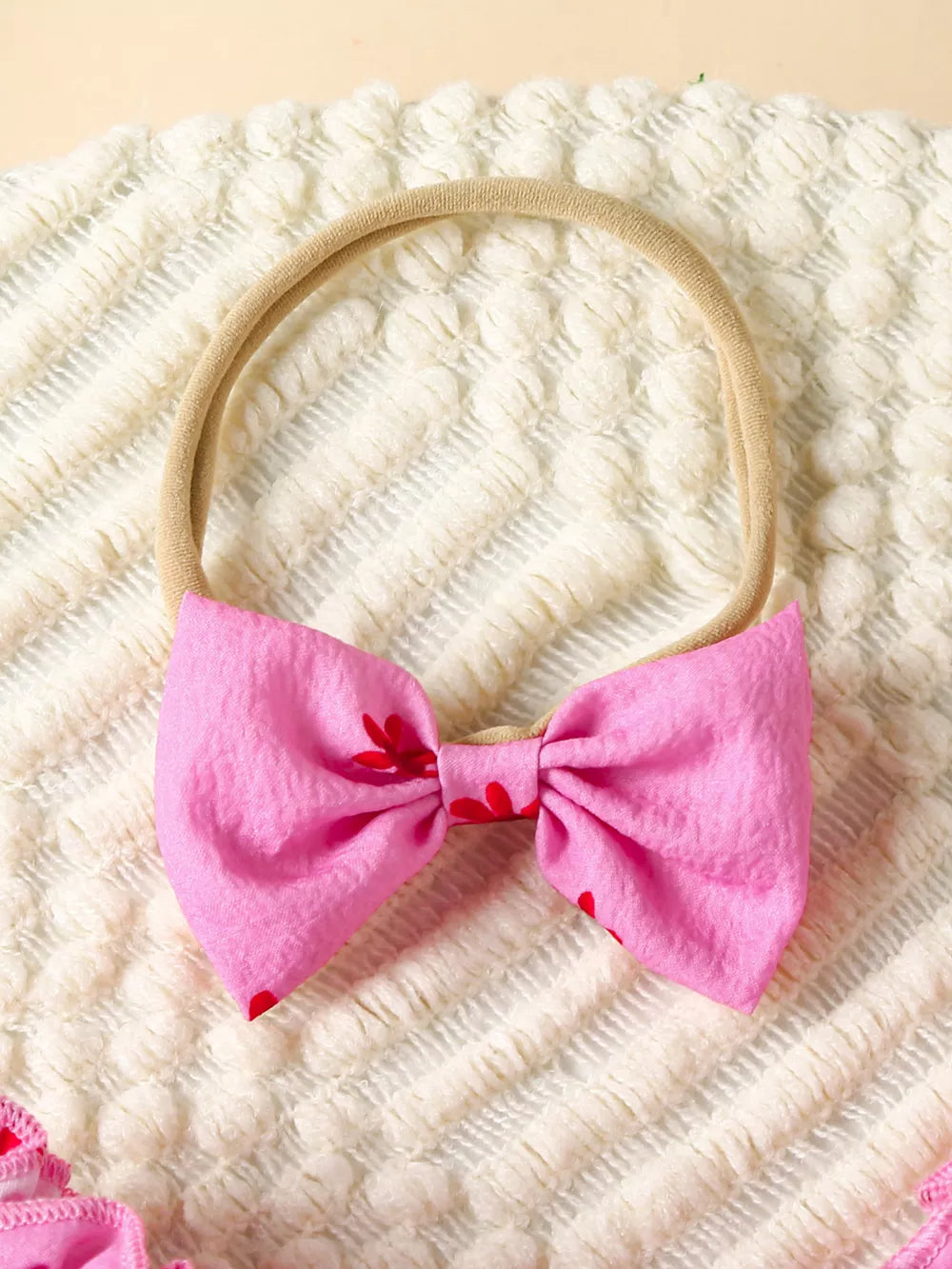 Pink floral baby bow headband with red flower accents.