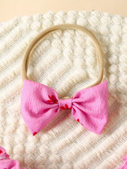 Pink floral baby bow headband with red flower accents.
