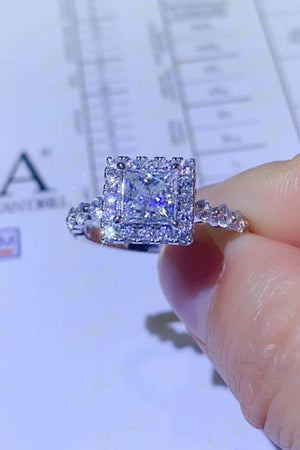 White moissanite engagement ring with cushion cut center stone and halo setting.