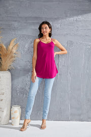 Cerise cami with spaghetti straps and curved hemline, worn with light wash jeans.