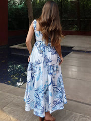 Maxi dress with blue tropical leaf print, tiered skirt, and lace trim.