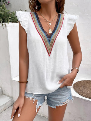 White V-neck blouse with flutter sleeves and colorful embroidered trim detail.